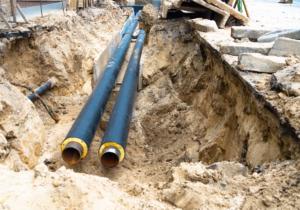 Two Water Pipes In Ground Pit Trench Ditch During Plumbing Under